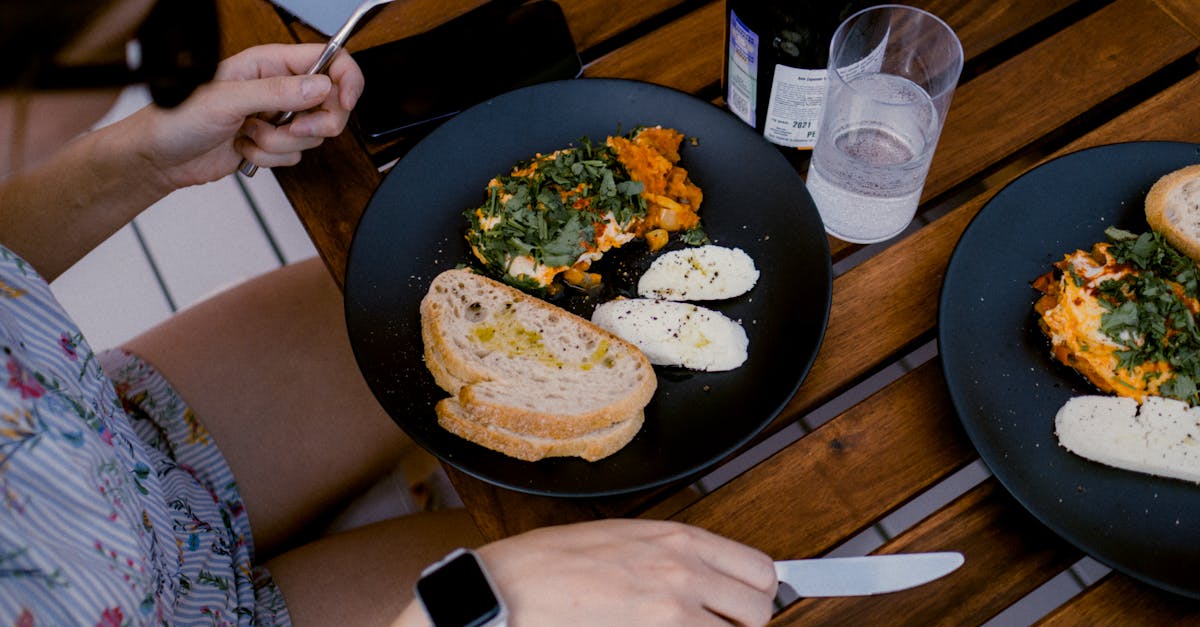 A tablet on a wooden table showing nutrition tracking data beside a plate of food